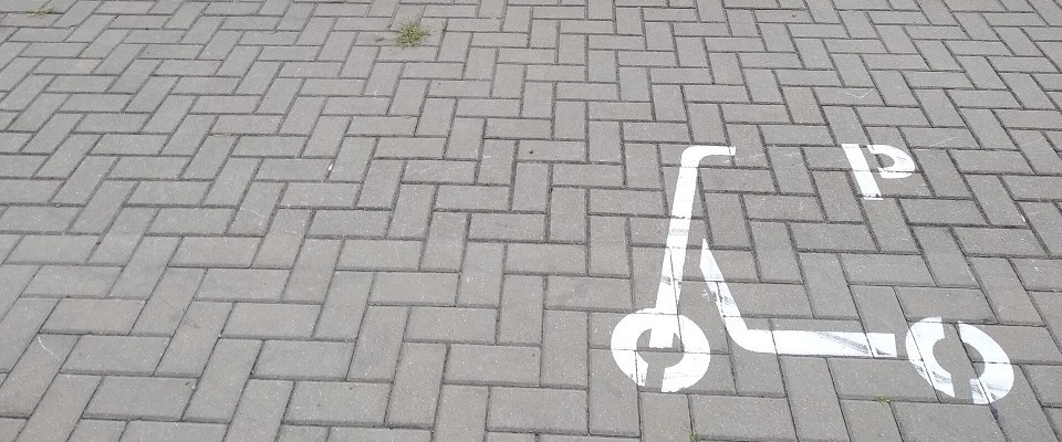A painted e-scooter parking bay marking on block paving