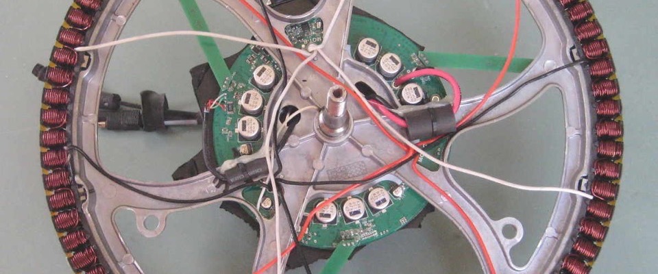 The opened stator of an e-bike hub motor, showing copper windings and controller board
